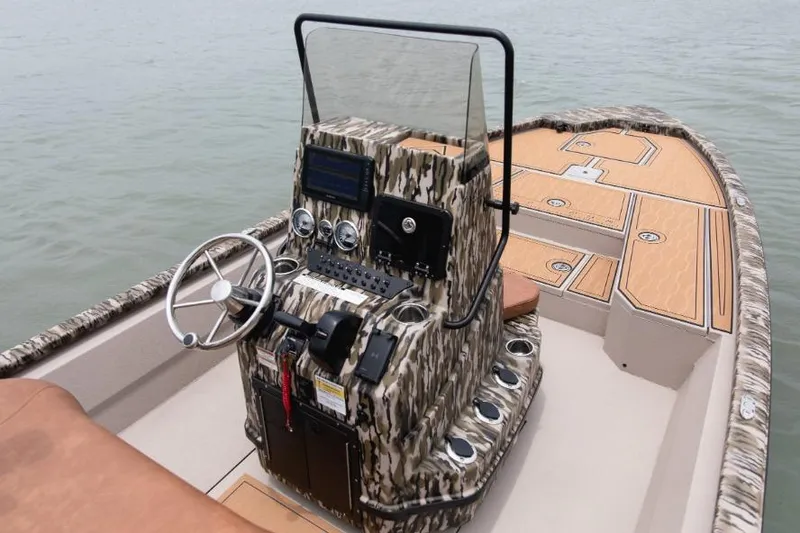 Slide: The Image of 2026 Avid 21 Fusion boat with camo console and modern controls on calm water. - 3