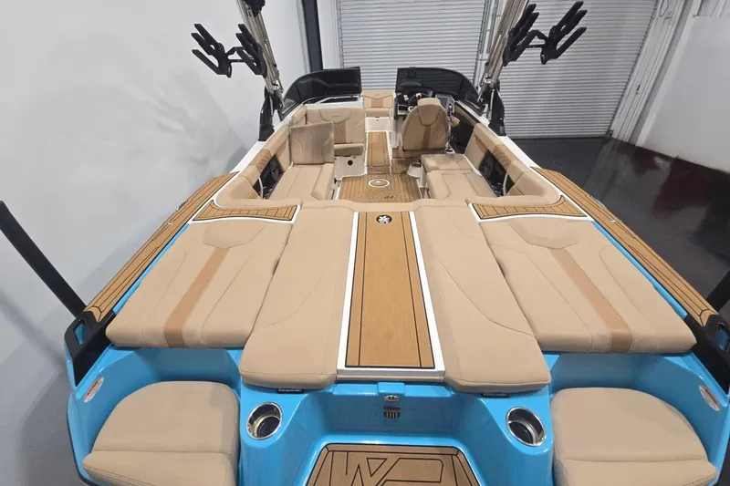 Slide: The Image of 2023 MasterCraft XT24 boat interior with beige seating and blue accents. - 4