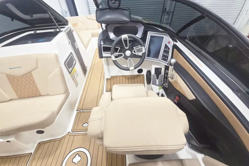 Slide: The Image of 2023 MasterCraft XT24 boat interior with beige seating and modern dashboard controls. - 5