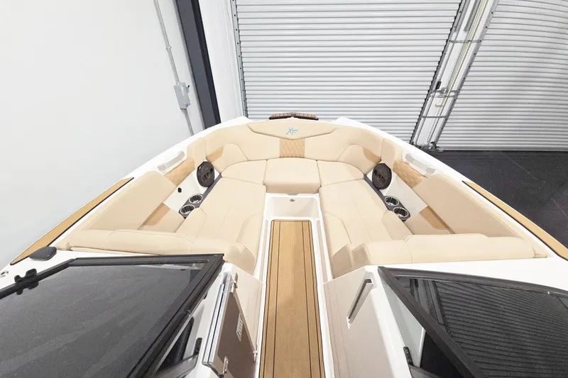 Slide: The Image of 2023 MasterCraft XT24 boat interior with beige seating and wood accents. - 8