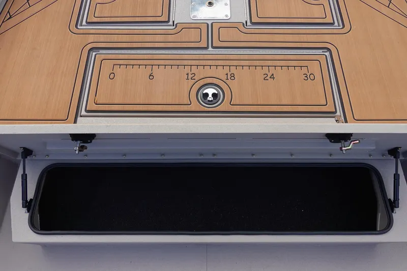 Slide: The Image of 2026 Avid 20 Rogue CC boat deck with storage compartment and measuring ruler. - 24