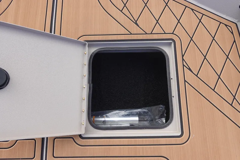 Slide: The Image of Open storage compartment on Avid 20 Rogue CC boat, 2026 model, with wooden deck design. - 27