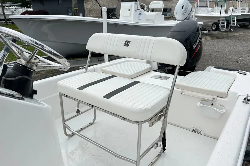 Slide: The Image of 2011 Carolina Skiff JVX18CC boat interior with white seating and steering wheel. - 11
