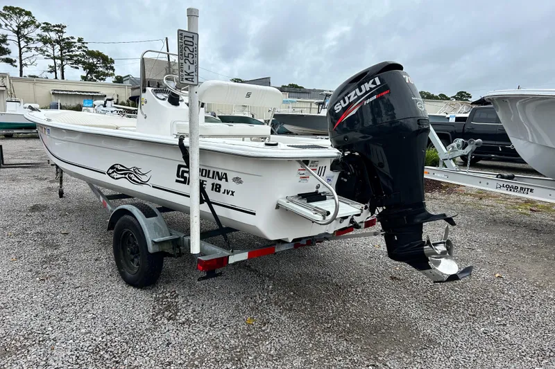 Slide: The Image of 2011 Carolina Skiff JVX18CC boat with Suzuki outboard motor on a trailer. - 2