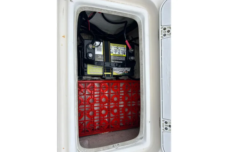 Slide: The Image of Battery compartment of a 2011 Carolina Skiff JVX18CC boat, featuring a marine battery. - 23