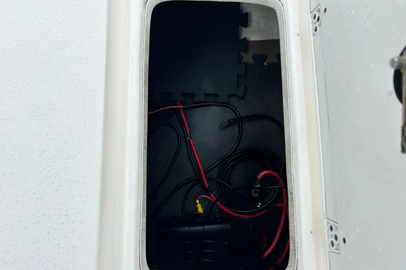 Slide: The Image of Storage compartment of a 2011 Carolina Skiff JVX18CC with wiring and cables. - 27