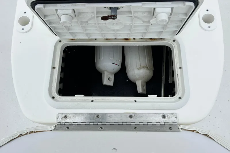 Slide: The Image of Open storage compartment on a 2011 Carolina Skiff JVX18CC boat, showing interior contents. - 28