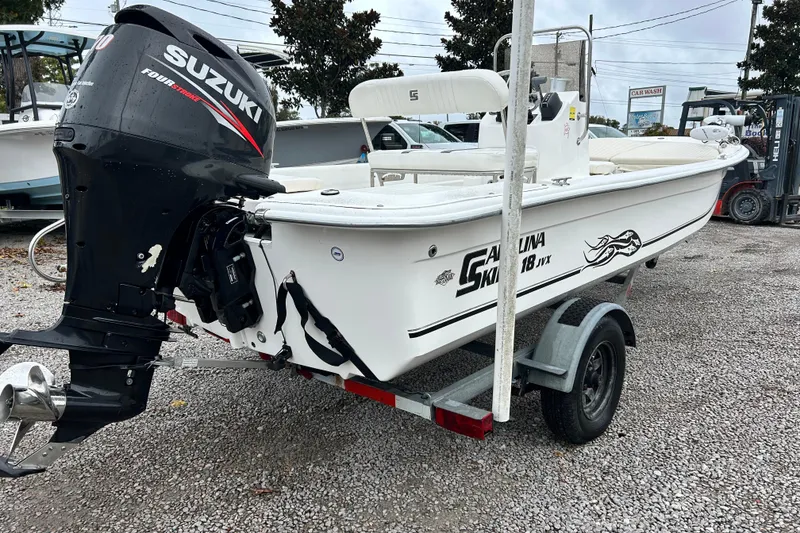 Slide: The Image of 2011 Carolina Skiff JVX18CC boat with Suzuki outboard motor on trailer. - 4