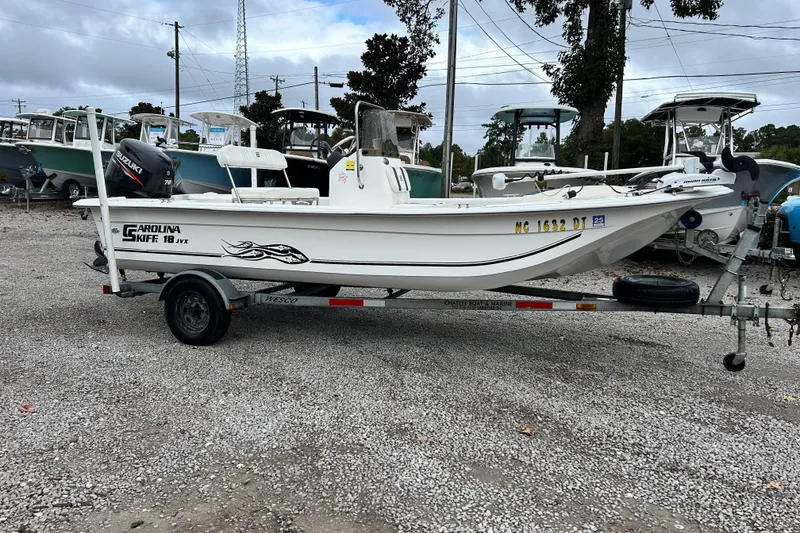 Slide: The Image of 2011 Carolina Skiff JVX18CC boat on trailer, parked in a gravel lot. - 5