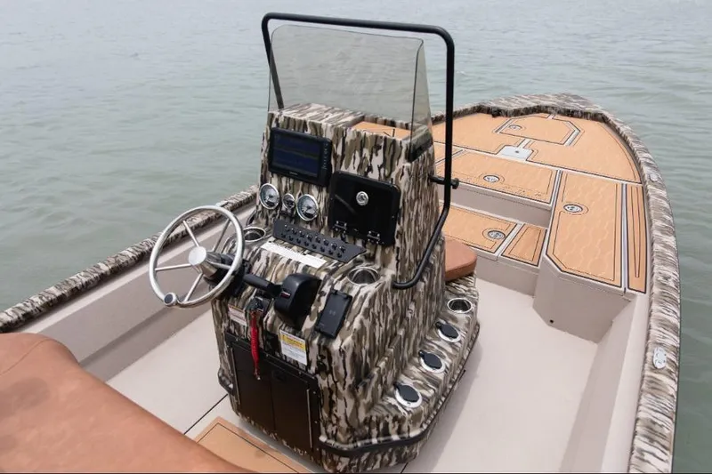 Slide: The Image of Avid 21 FST 2026 boat with camo console and spacious deck on water. - 4
