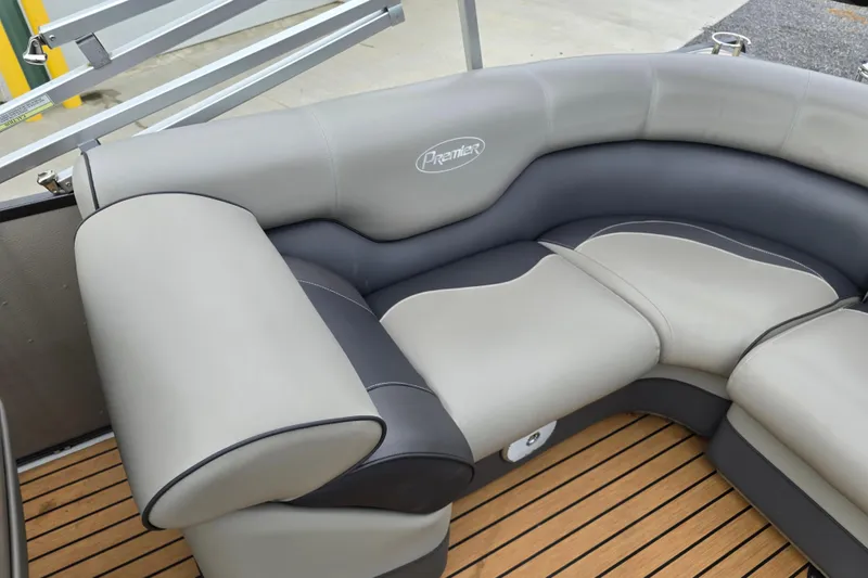 Slide: The Image of 2015 Premier 230 SunSation RF pontoon boat with black cover, parked near a green building. - 10