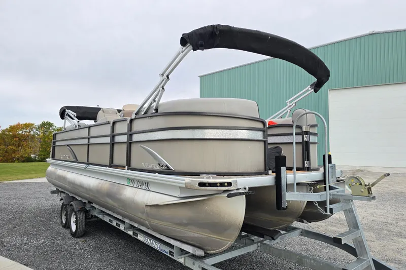 Slide: The Image of 2015 Premier 230 SunSation RF pontoon boat on trailer near industrial building. - 3