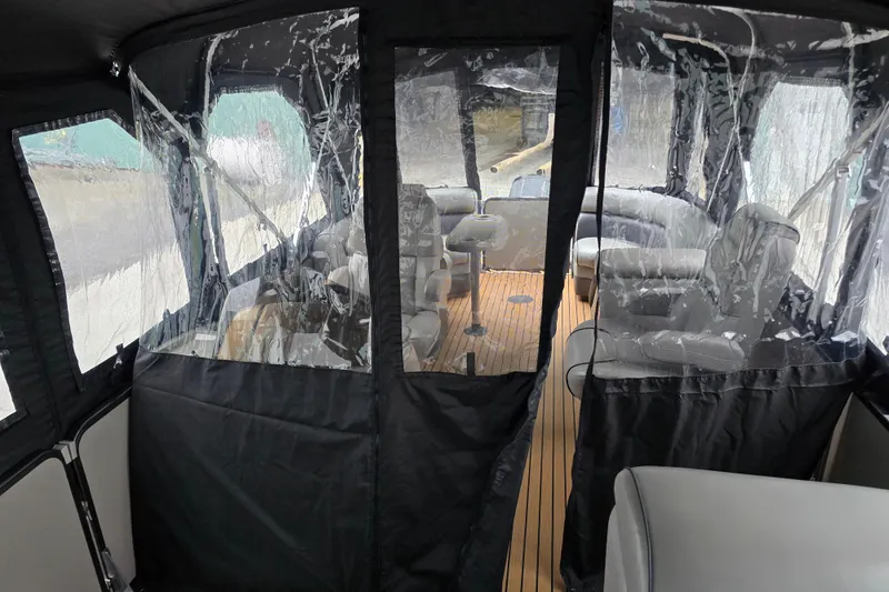 Slide: The Image of 2015 Premier 230 SunSation RF boat interior with clear vinyl enclosure and seating. - 48