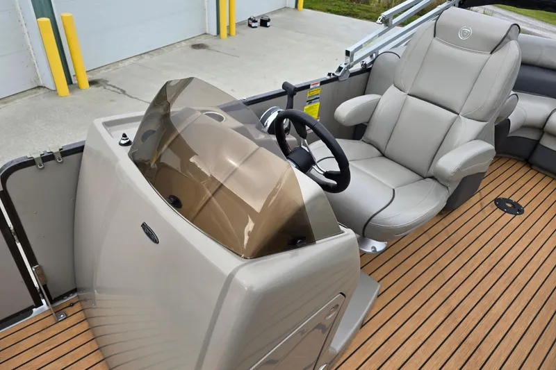 Slide: The Image of 2015 Premier 230 SunSation RF pontoon boat with black canopy, parked outside a large building. - 6