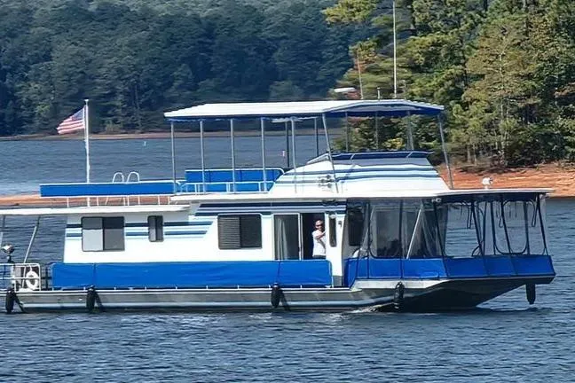 The Image of 1988 Sumerset 14x65 houseboat on a lake with trees in the background. - 0