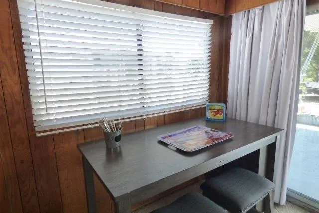 Slide: The Image of 1988 Sumerset 14x65 houseboat interior with wooden walls, table, and window blinds. - 5