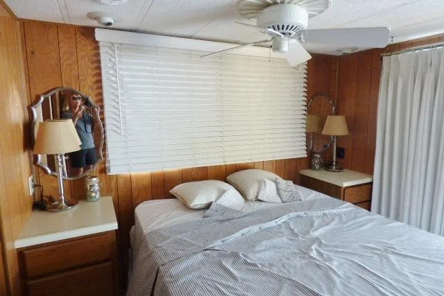 Slide: The Image of Cozy bedroom in 1988 Sumerset 14x65 houseboat with wood paneling and ceiling fan. - 7