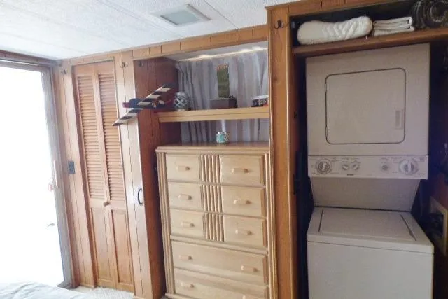 Slide: The Image of Interior of a 1988 Sumerset 14x65 houseboat with wooden cabinets and a stacked washer-dryer. - 8