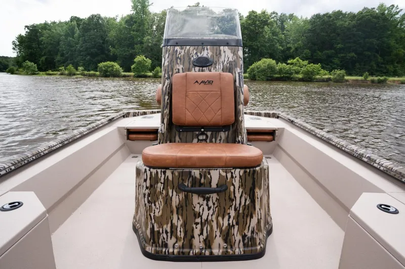 Slide: The Image of Avid 21 Recon 2026 boat with camo design on a serene lake. - 10