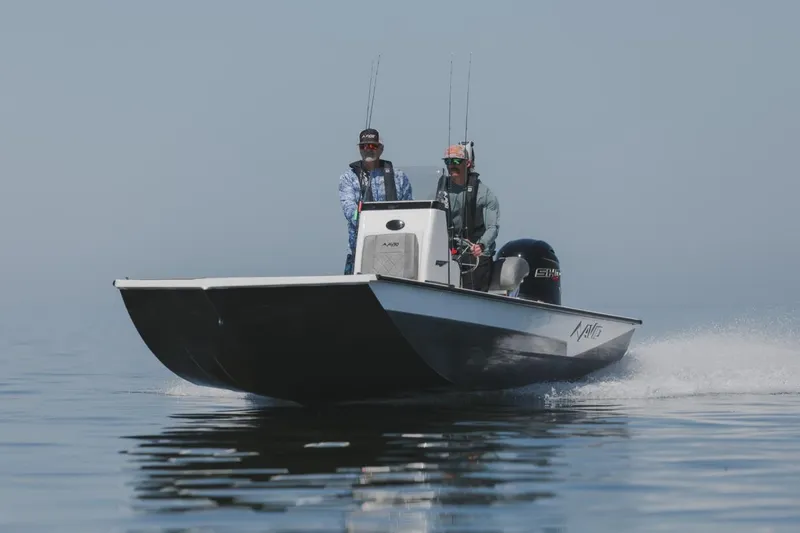 Slide: The Image of 2026 Avid 21 Recon boat cruising on calm water with two passengers. - 13