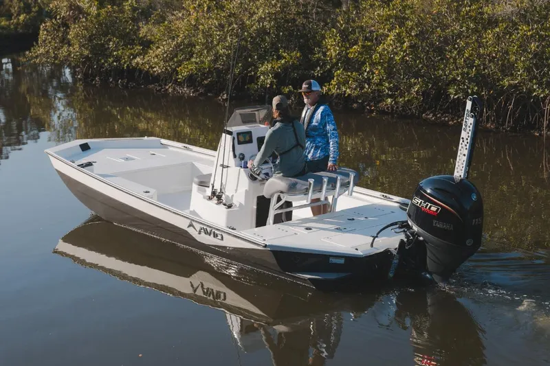 Slide: The Image of 2026 Avid 21 Recon boat navigating a calm river with two passengers onboard. - 3
