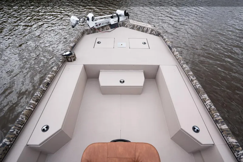 Slide: The Image of Avid 21 Recon 2026 boat interior with seating and storage on calm water. - 4