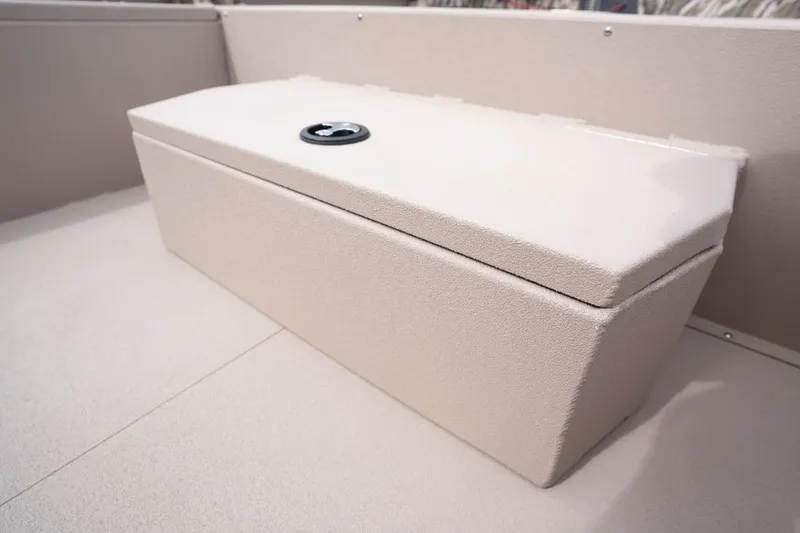 Slide: The Image of Avid 21 Recon 2026 boat storage compartment with secure latch, beige interior. - 9