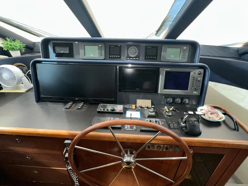 Slide: The Image of 2003 Pacific Mariner 65 SE Motoryacht helm with navigation instruments and wooden steering wheel. - 23