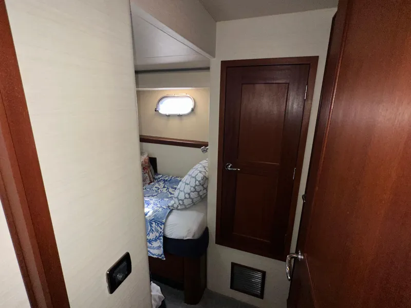 Slide: The Image of Cozy bedroom interior of 2003 Pacific Mariner 65 SE Motoryacht with wooden door and porthole. - 29