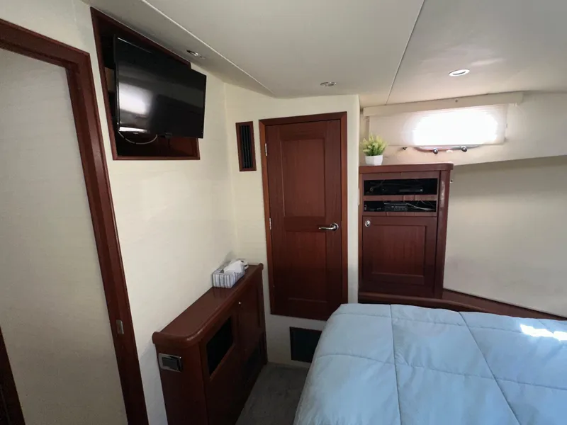 Slide: The Image of Interior of 2003 Pacific Mariner 65 SE Motoryacht bedroom with TV and wooden cabinetry. - 31
