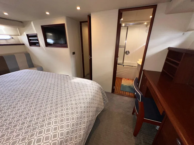 Slide: The Image of 2003 Pacific Mariner 65 SE Motoryacht bedroom with ensuite bathroom and desk area. - 41
