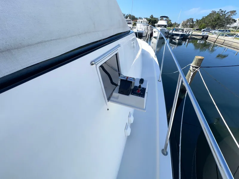 Slide: The Image of 2003 Pacific Mariner 65 SE Motoryacht side deck with control panel, docked at marina. - 47