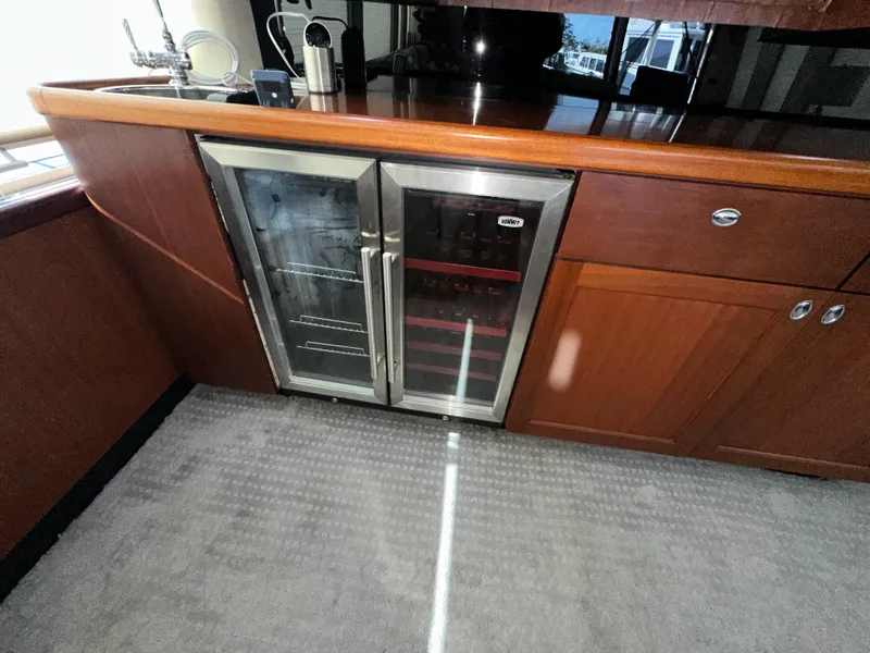 Slide: The Image of 2003 Pacific Mariner 65 SE Motoryacht interior with wooden cabinetry and built-in wine cooler. - 5