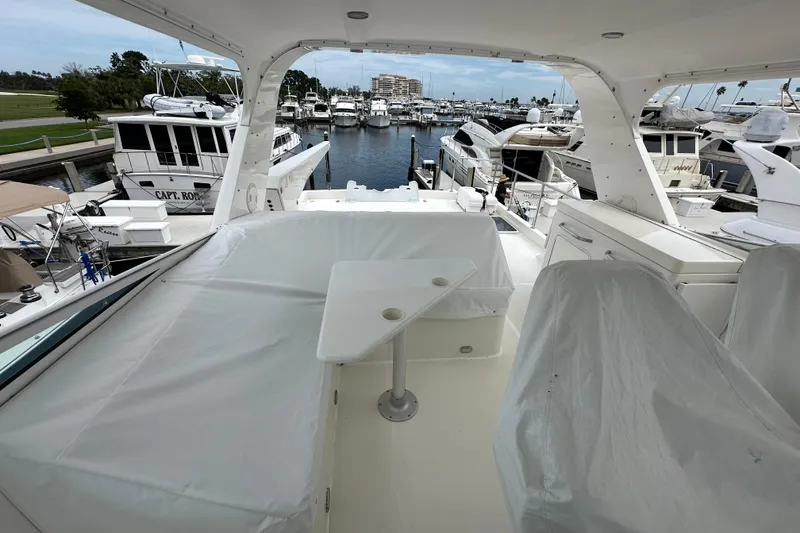 Slide: The Image of 2003 Pacific Mariner 65 SE Motoryacht docked at marina, featuring covered seating area. - 52