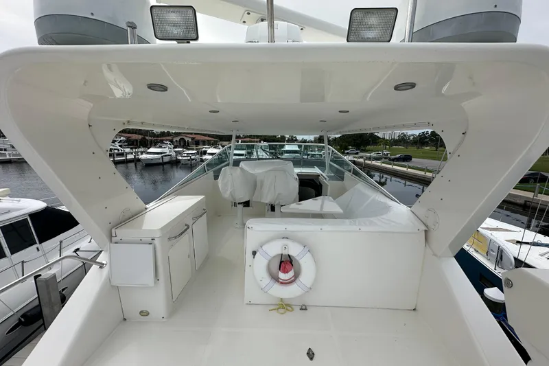 Slide: The Image of 2003 Pacific Mariner 65 SE Motoryacht deck with marina view and safety equipment. - 54