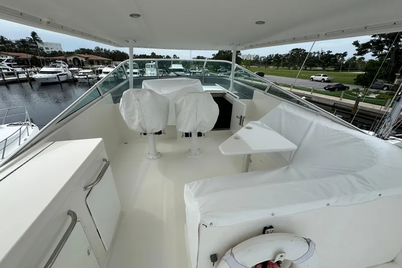 Slide: The Image of 2003 Pacific Mariner 65 SE Motoryacht flybridge with covered seating and marina view. - 55