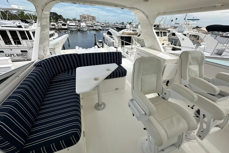 Slide: The Image of 2003 Pacific Mariner 65 SE Motoryacht interior with striped seating and helm chairs in marina. - 61