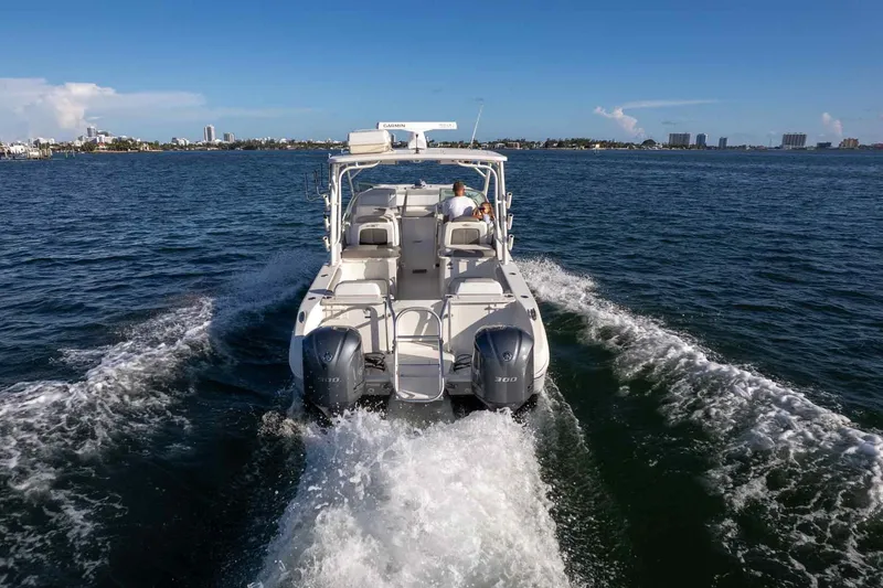 Slide: The Image of 2017 World Cat 295 DC cruising on open water, rear view with twin engines. - 11