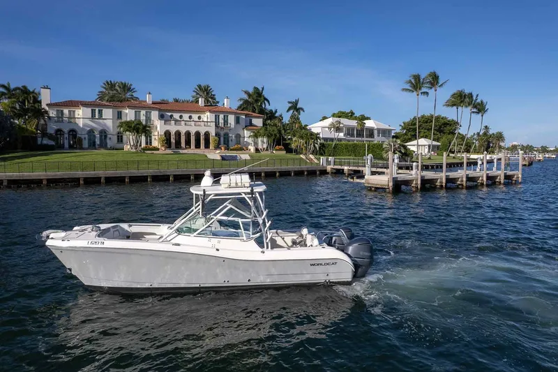 Slide: The Image of 2017 World Cat 295 DC boat cruising near luxury waterfront homes and docks. - 15