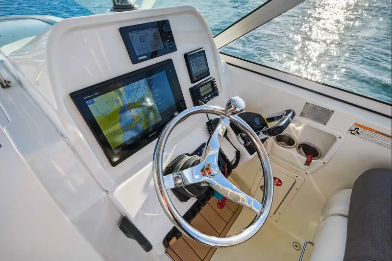 Slide: The Image of Helm of 2017 World Cat 295 DC boat with navigation screens and steering wheel. - 19