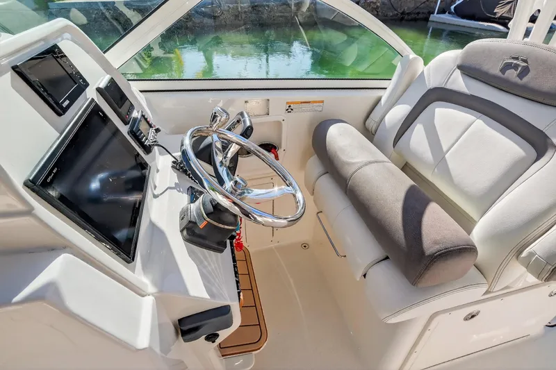 Slide: The Image of 2017 World Cat 295 DC boat helm with steering wheel and navigation screens. - 20