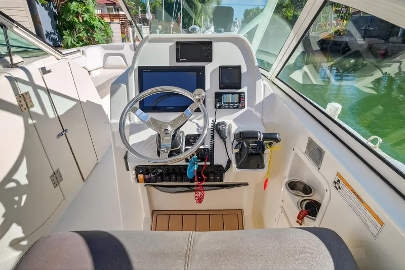 Slide: The Image of Cockpit of 2017 World Cat 295 DC boat with steering wheel and navigation controls. - 21