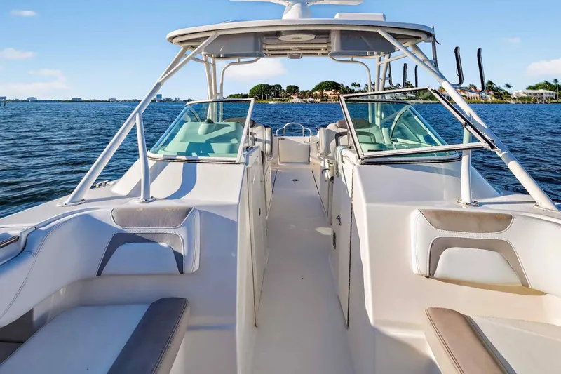Slide: The Image of 2017 World Cat 295 DC boat on calm water, showcasing spacious seating and sleek design. - 22
