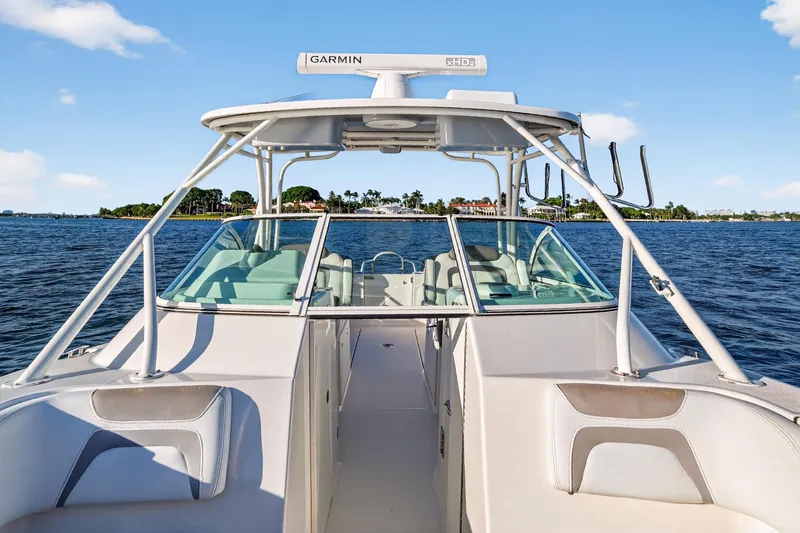 Slide: The Image of 2017 World Cat 295 DC boat on water, featuring Garmin radar, clear sky background. - 24