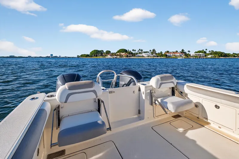 Slide: The Image of 2017 World Cat 295 DC boat on water, featuring spacious seating and scenic coastal view. - 26