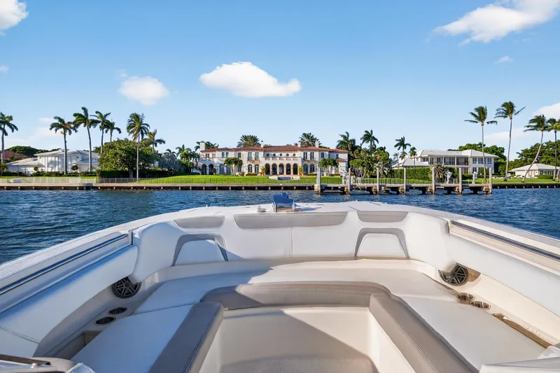Slide: The Image of Front view from a 2017 World Cat 295 DC boat, overlooking waterfront mansions and palm trees. - 31