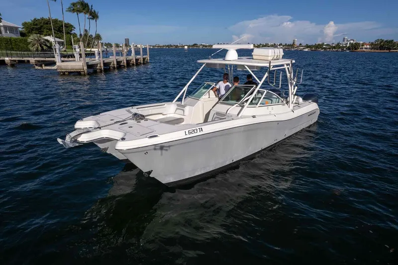 Slide: The Image of 2017 World Cat 295 DC boat cruising on a sunny day near a dock. - 34