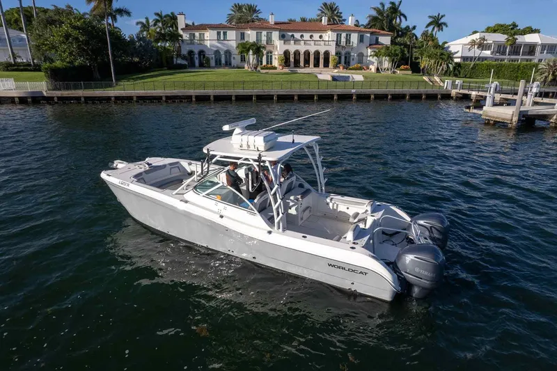 Slide: The Image of 2017 World Cat 295 DC boat cruising near luxurious waterfront mansion. - 37