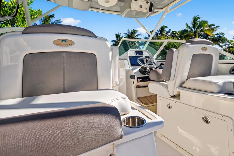 Slide: The Image of 2017 World Cat 295 DC boat interior with helm, seats, and tropical background. - 43