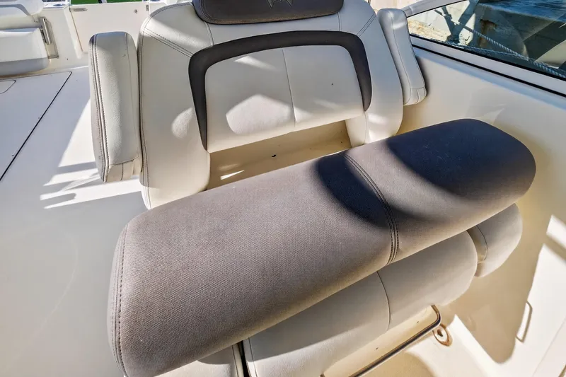 Slide: The Image of 2017 World Cat 295 DC boat seat with cushioned armrest in sunlight. - 44